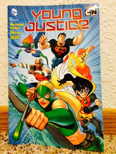 [Image is a graphic novel cover of Young Justice. It shows 6 superheroes. One is flying, one is Superboy wearing a t-shirt with a Superman logo on it. There's Kid Flash off to the right running. There's Aqua Lad who shoots water. Robin is near the cover. Finally, Artemis is holding a green bow and arrow]