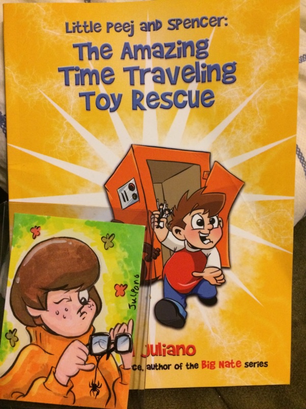[Image features a comic titled "Little Peej and Spencer: The Amazing Time Traveling Toy Rescue by Phil Juliano". To the bottom left, there's a cartoon image of Velma from Scooby Doo cleaning her glasses." 