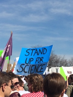 [Another protest sign that reads "Stand up for Science"]