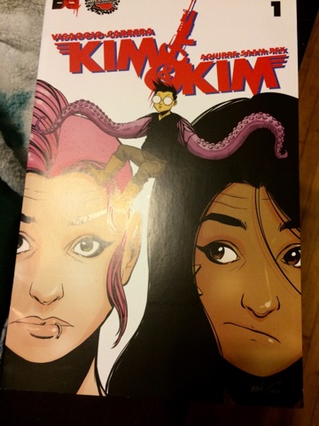 [Image is a comic book cover. The title says "Kim & Kim" It shows two women close together with a boy in the center with tentacles for arms]