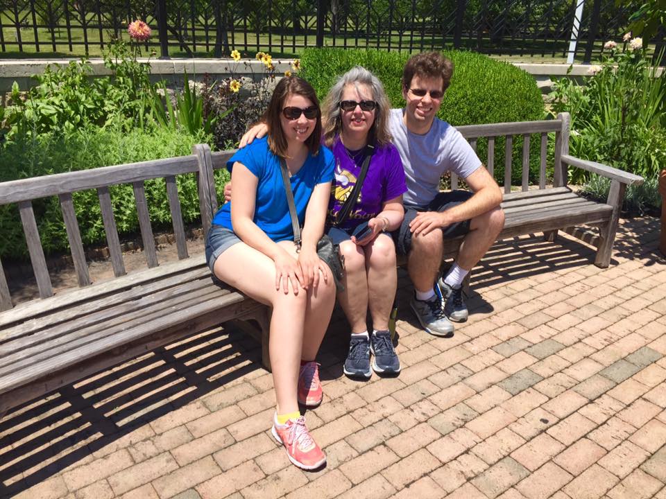 [Image is a picture of 3 people sitting on a bench. It's a really sunny day]