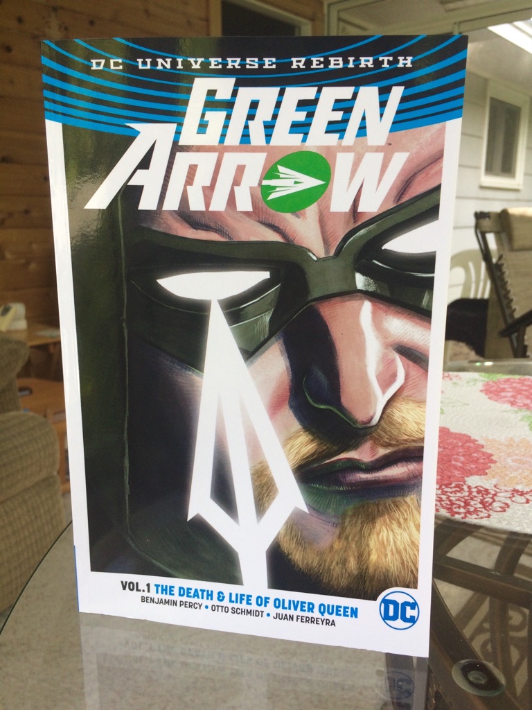 [Image is a cover of a graphic novel. It's a "DC Universe Rebirth - Green Arrow Vol #1 The Death & Life of Oliver Queen" by Benjamin Percy, Otto Schmidt, and Juan Ferreyra. The cover features a white shining arrow with a man in a green hood.] 