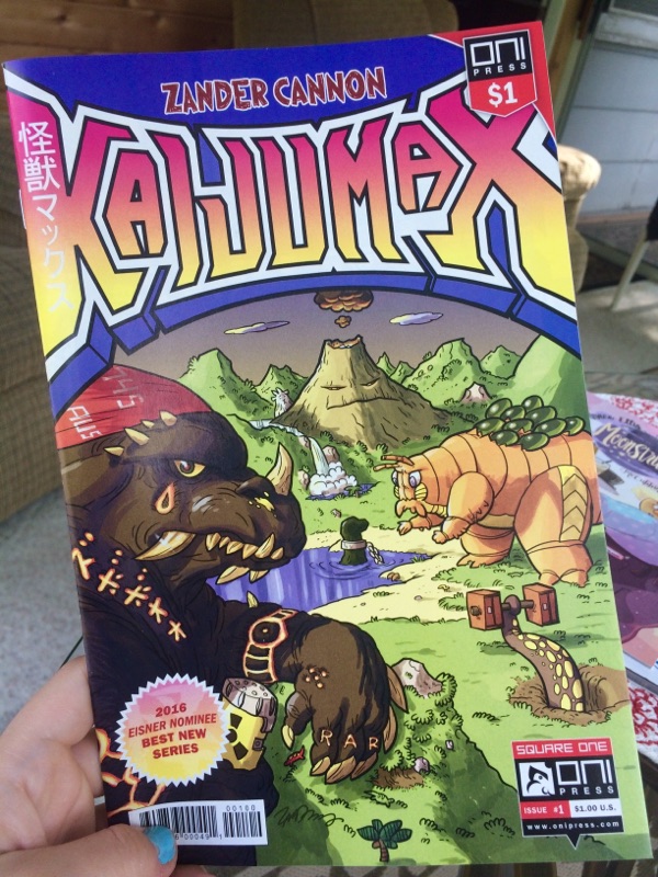 [Image is a comic book cover for Kaijumax. On the cover there's a volcano and two creatures on it. The one on the left looks like a Dinosaur and the other creature looks like a massive bug / dinosaur creature]