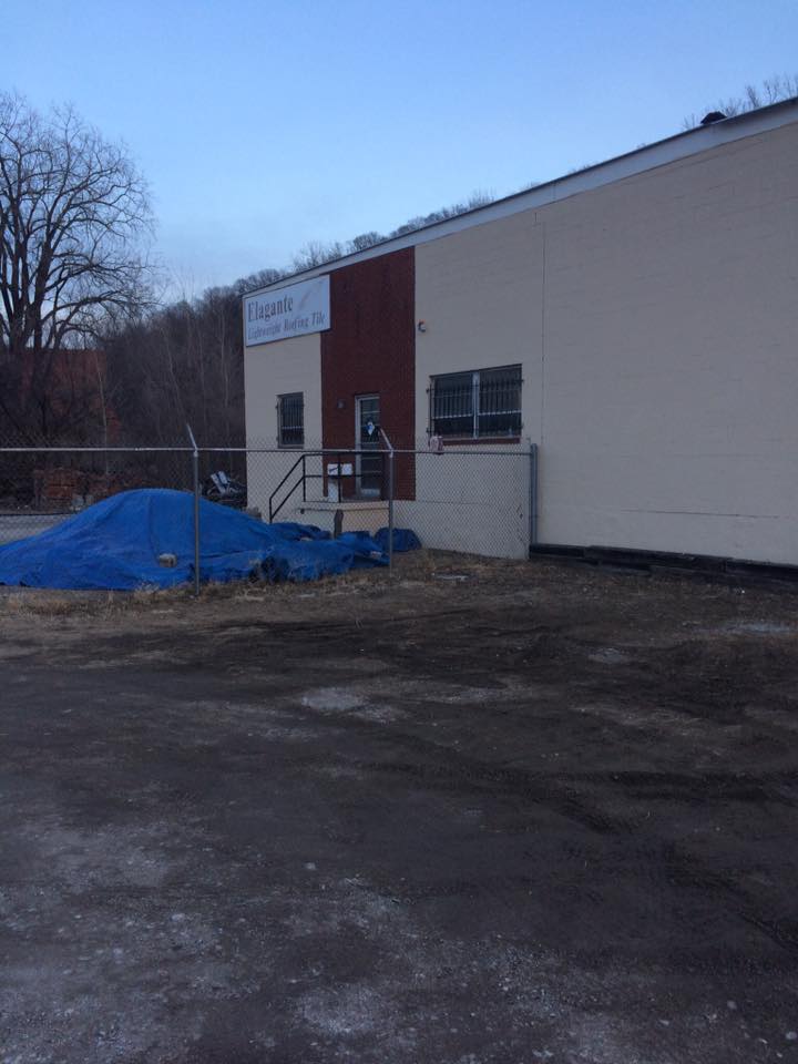 [Outside of the Air BnB. Photo appears to be at an abandoned warehouse with a gate and a blue tarp in the background]