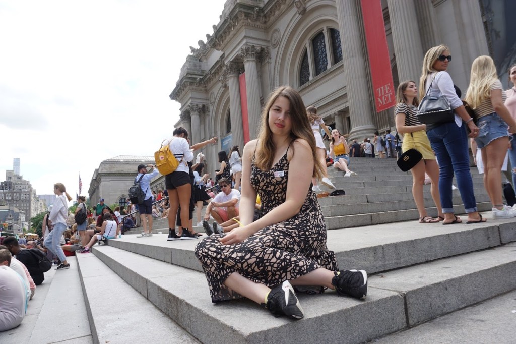 Image is a photo of me outside The Met in NYC. I'm sitting on a set of stairs outside the building. 