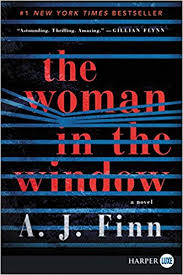 [Image is a book cover. It's black with blinds being pressed open. Part of the title of the book sits on the blinds. It says "The Woman in the Window"]