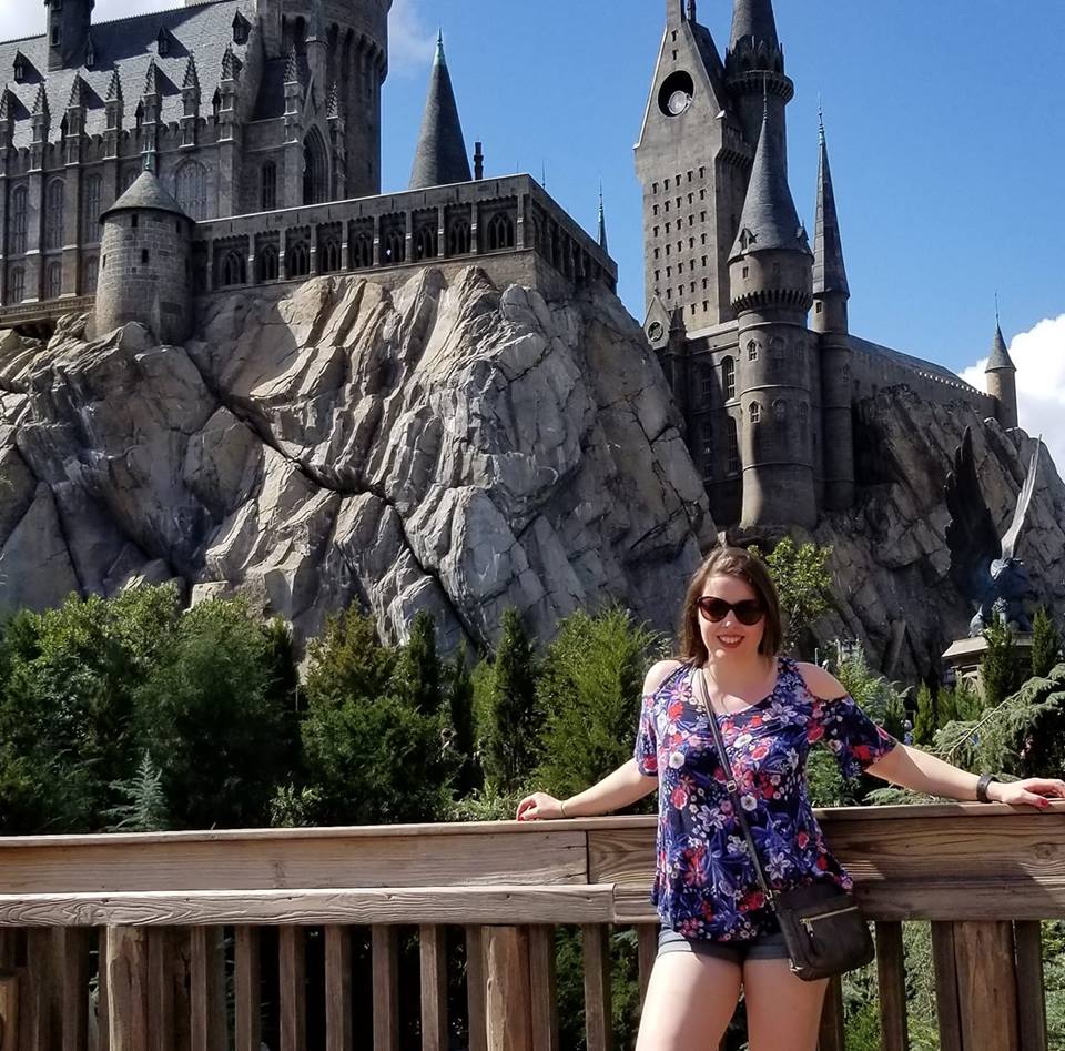 Image is a photo of me standing in front of Hogwarts castle. I'm smiling at the camera. 