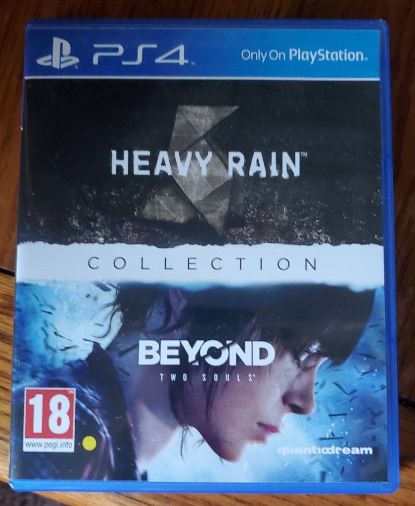 Image is a photo of a PS4 game titled Heavy Rain and Beyond Two Souls. It's a collection, so it's two games in one. The top half of the game shows rain and in the rain is an origami paper statue. The bottom half shows a woman looking down. 