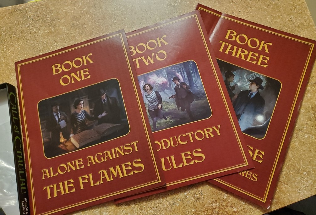 Image is all three books laid out next to each other. The first book Alone Against the Flames. Book Two Introductory Rules and Book Three, the title hidden as Book Two is overlaying Book Three. 