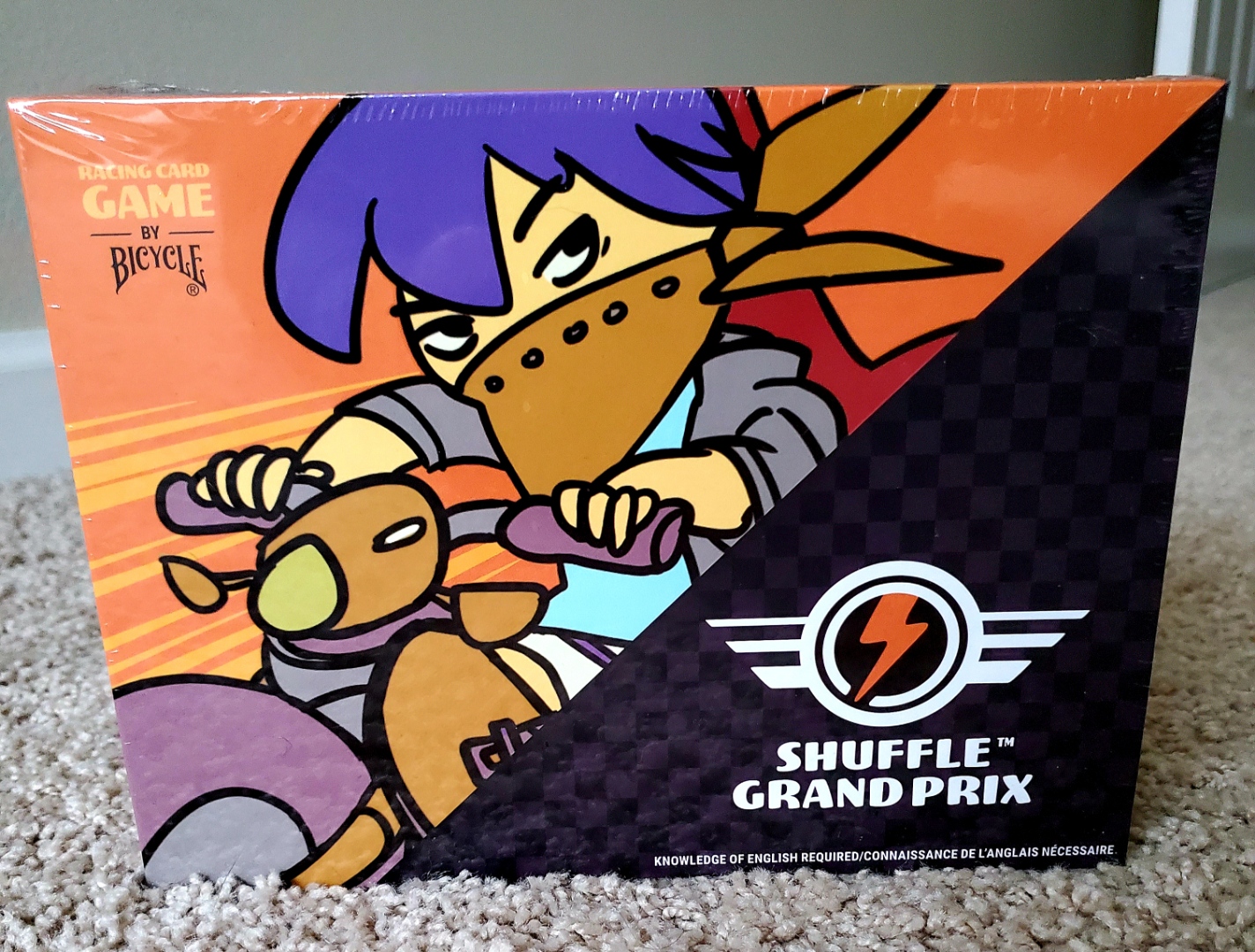 Image is a photo of the game Shuffle Grand Prix. It shows a cartoon character on a cartoon motorcycle. They are wearing a brown bandana around their nose and mouth. 