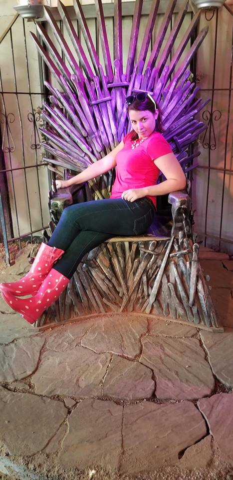 Image is a photo of me sitting on an Iron Throne very similar to the throne in Game of Thrones. 