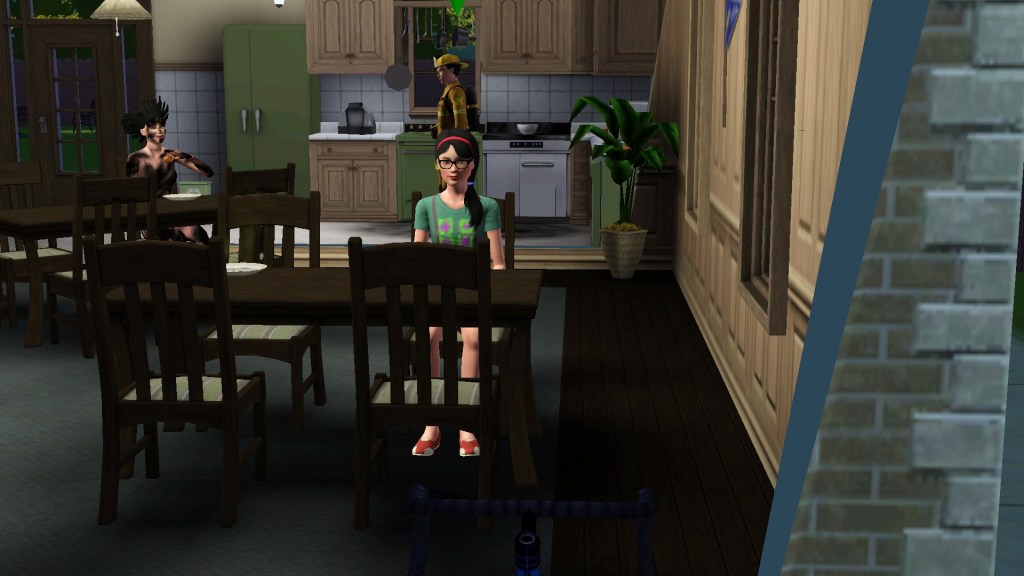 Image is a screenshot from The Sims 3. It shows a woman sitting at a table. She's wearing a red headband with a braid in her hair. Behind her, is a kitchen which another Sim is in. 