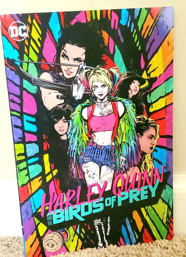 Image is a photo of a graphic novel called Harley Quinn Birds of Prey. It's a cover with Margot Robbie front and center with several of the movie characters behind her. 