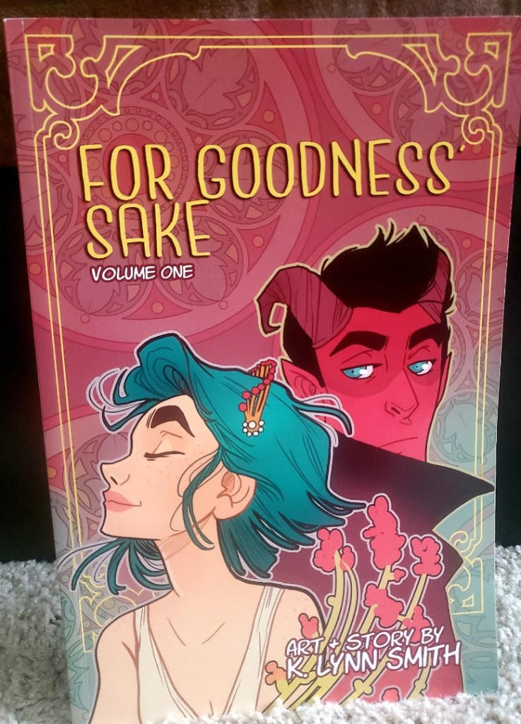 Image is a graphic novel cover for Food Goodness Sake Volume One by K. Lynn Smith. It shows a woman with blue hair on the cover. Behind her is a devil. He is side eyeing her. 