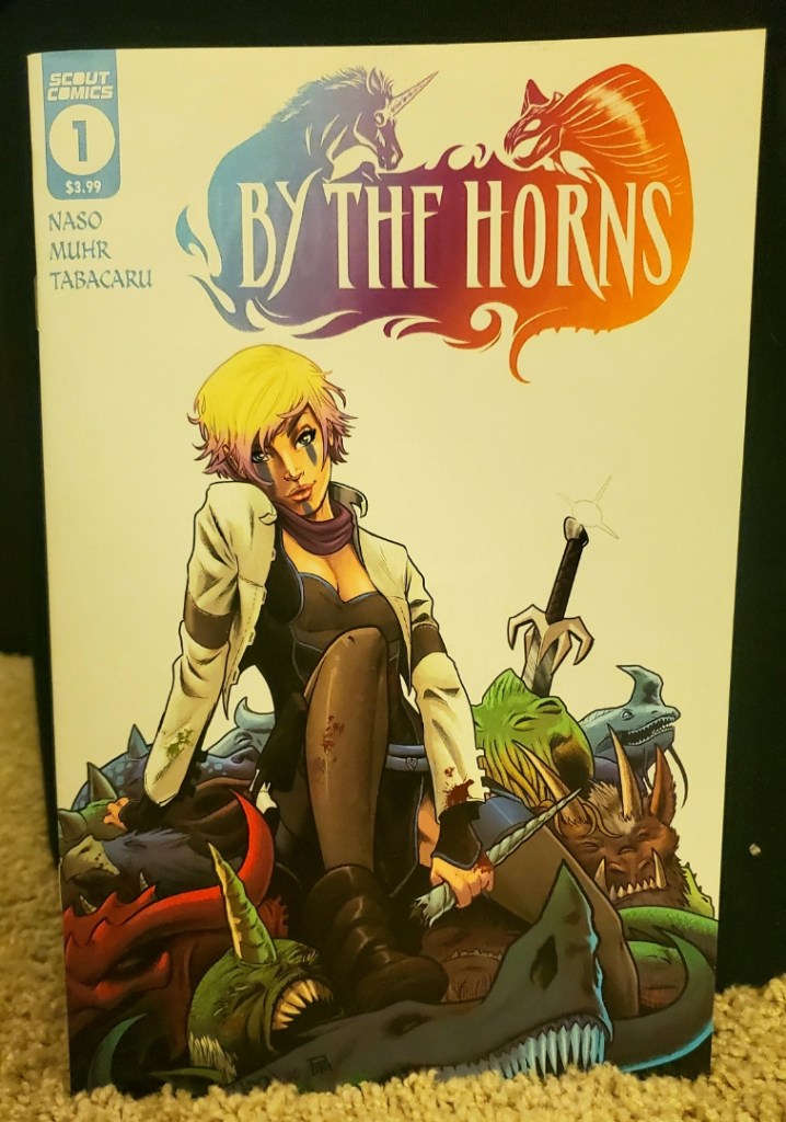Image is for a comic book cover for By The Horns. It shows a woman with short blonde hair wearing a white jacket. She's sitting on a pile of dead creatures. Her sword is sticking into something next to her. 