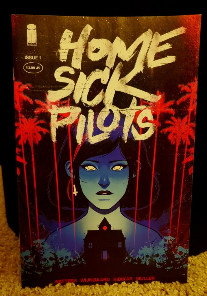Image is a comic book cover for Home Sick Pilots. It shows a woman in blue staring straight ahead. Beneath her is a black house. There are red dripping palm trees of sorts. 