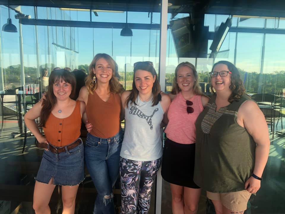 Image is a photo of five women. We are all smiling at the camera. 
