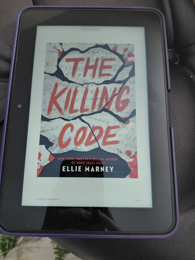 Image is a photo of the book cover for The Killing Code, taken from my kindle. It shows scraps of white paper being meshed together sort of like a puzzle. Some of the pages are stained red with blood. 