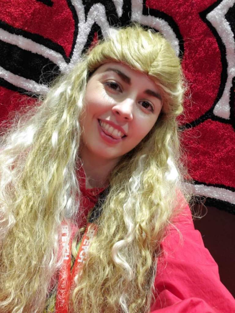 [Image is a selfie of a woman standing near a sign]