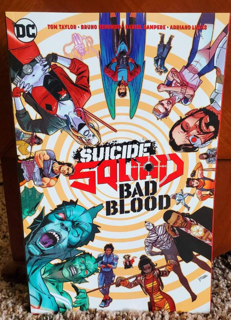 [Image is a comic cover. The title is "Suicide Squad Bad Blood. There are several people on this cover who are rotated throughout the image. Most of them look extremely menacing]