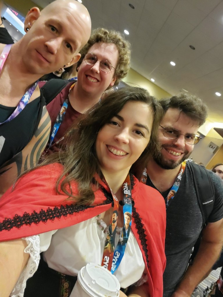 [Image is a selfie of four people. They are all smiling looking at the camera]