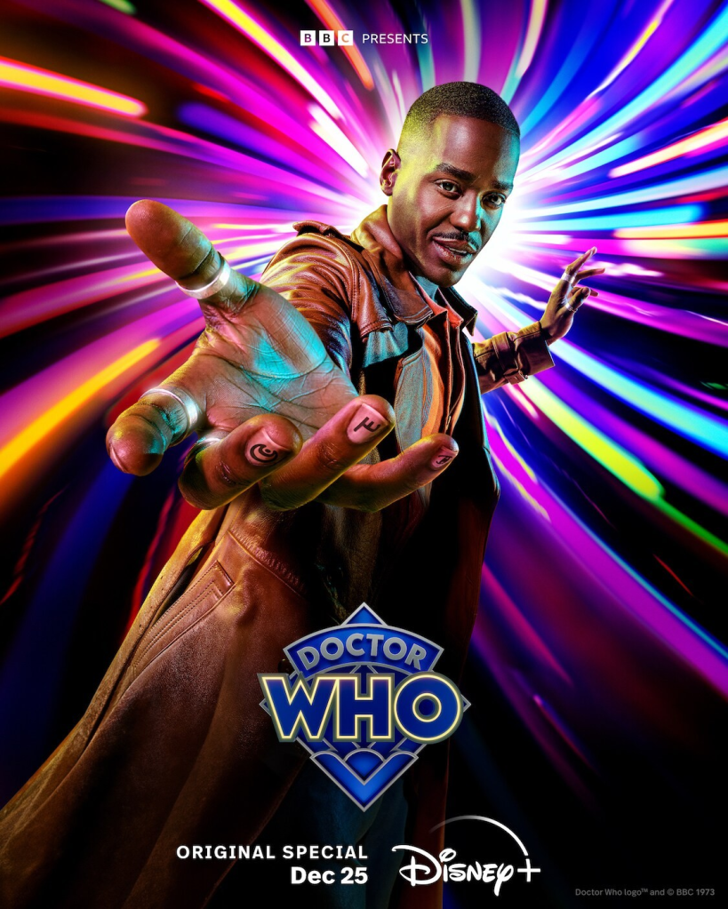 Image is a promotonal poster for Doctor Who. It shows a black background with vertical lines of bright light including purple, orange, green and blue. A man is holding his hands out to the viewer. It says at the bottom "Doctor Who Original Special December 25 Disney+"