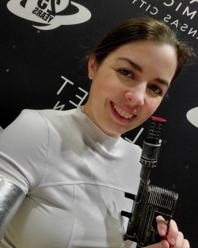 Image is a photo of me holding a blaster smiling at the camera. 