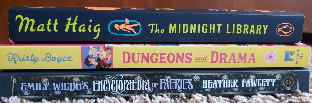 Image is a stack of three books. The first book is The Midnight Library by Matt Haig. The second book is Duneons and Drama by Kristy Boyce and the third book is Emily Wilde's Encyclopaedia of Faeries by Heather Fawcett". 