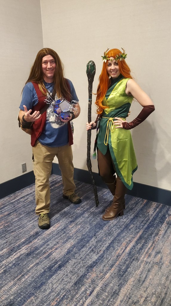 Me in my Keyleth cosplay and Matt Mercer. A man wearing a long brown wig, blue t-shirt, and a hexagon prop in his left hand. 