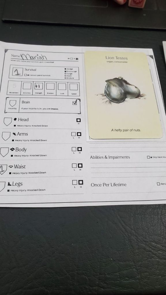 Image is a photo of a character sheet with the name "Mariah" written on it. To the right is a card of Lion Testes which is quite literally lion testicles. 