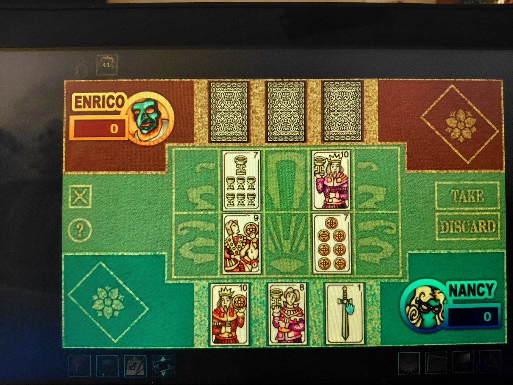 Image is a photo of a bird's eye view of a table and card game. On each side of the table are three slots for cards. There are 10 slots to play cards. On the table are four cards, one card has a 7 and 7 goblets on it, one card has a king with the 10 on it holding a goblet, there's a man holding a coin with 9 on the card and a card with 7 coins and the number 7 on it. 
