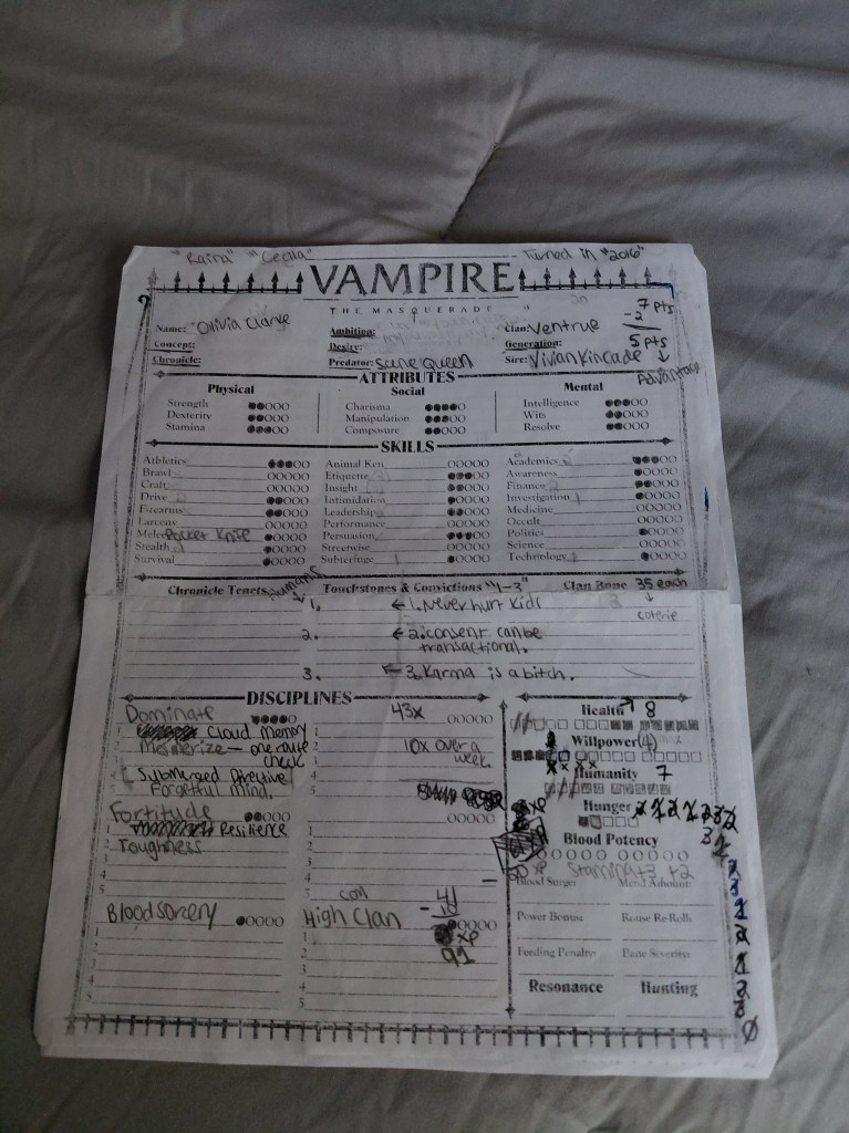 Image is a photo of a Vampire: The Masquerade character sheet. In the name it says "Olivia Clarke" and there are several dots filled in under Skills. There are several handwritten and crossed out numbers off to the right. 